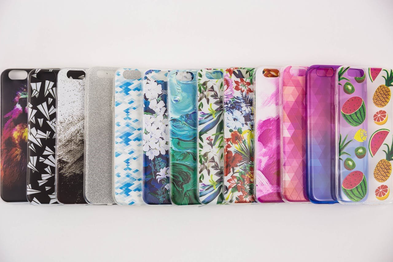 A vibrant collection of variously patterned iPhone cases arranged on a white surface.